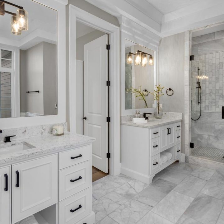 An elegant bathroom with marble flooring and countertop, wide vanity area and a shower area